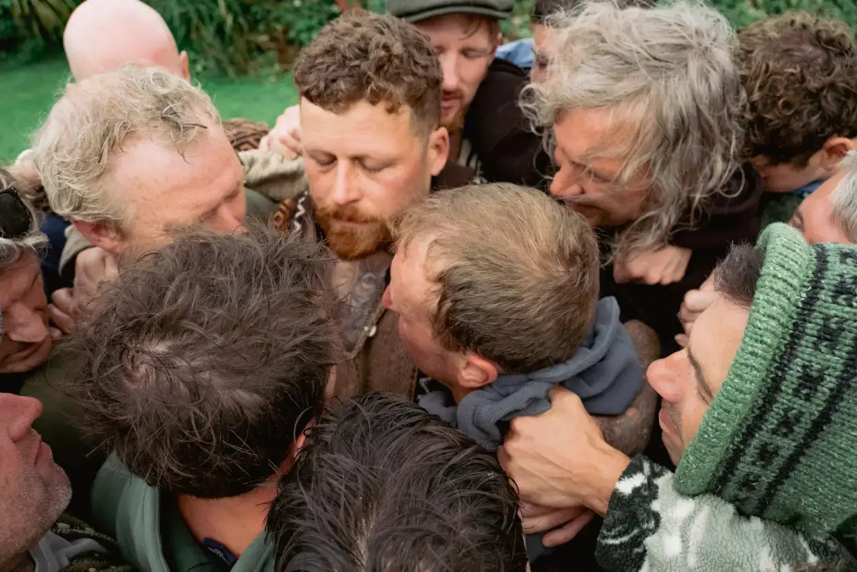 A circle of men with heads together in a huddle