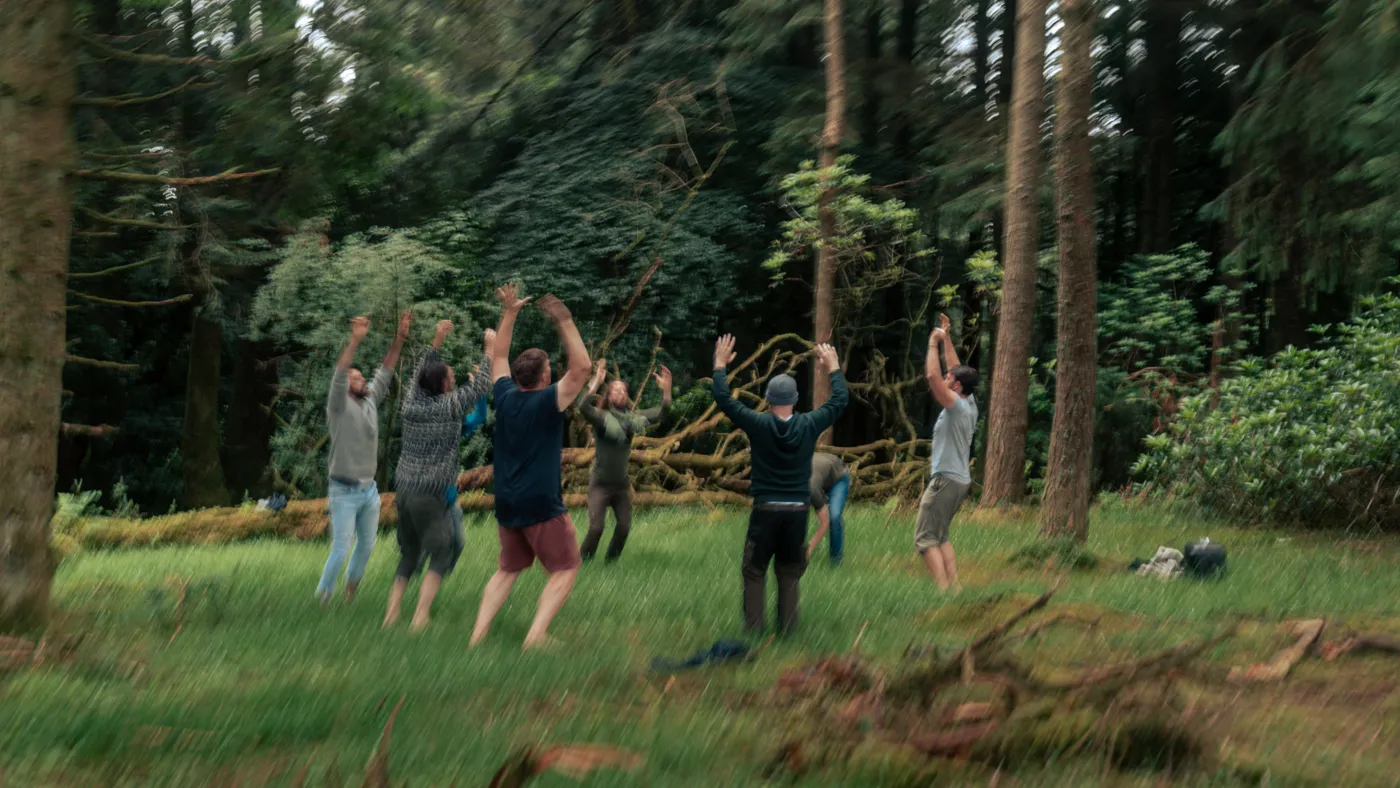 Men practising embodiment in the woods